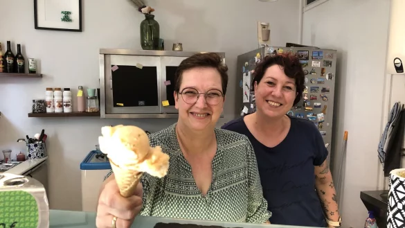 Daniela (links) und Inna vom Team der Eisperle in Detmold mit einer Kugel Orange-Gurke-Wassermelone. - © Chiara Wibbeke