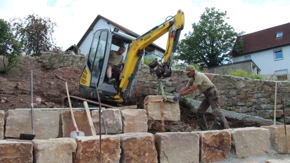 Marius-Alexander Engelking (links) und Ulrich Reineke setzen einen der letzten Steine f&uuml;r das neue Amphitheater in Talle. - &copy; Nadine Uphoff