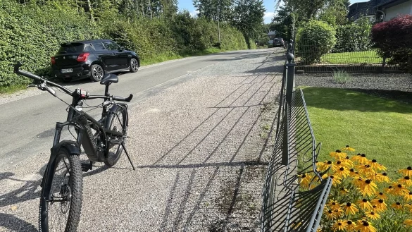 Wo die Roteiche von dem bewaldeten Grundst&uuml;ck (links) auf den Zaun gefallen ist, hat sie Spuren hinterlassen. Der Zaun ist noch nicht repariert. Auf der Kiesfl&auml;che stand der BMW, der bei dem Ereignis total demoliert wurde. - &copy; Silke Buhrmester