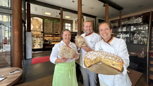 Serviceleitung Julia Wiebe (links) und Nicolas Biere zeigen jeweils ein Ruchmehlbrot, Denise Spintzyk einen gedeckten Apfelkuchen in der Bäckerei Biere im Café Gothland. - © Alexandra Schaller
