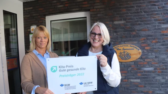 Manja Fischer (links) und Kita-Leiterin Elke Schlepphorst zeigen das Schild, das belegt, wof&uuml;r das Familienzentrum Kita Spatzennest ausgezeichnet worden ist. - &copy; Birgit Guhlke