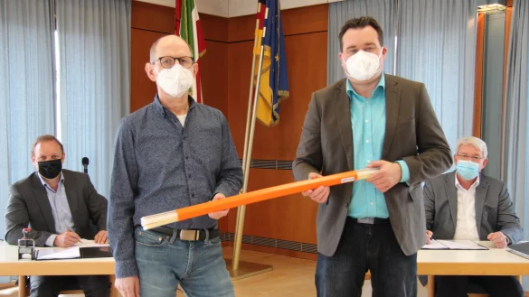 Kai-Timo Wilke, Gesch&auml;ftsf&uuml;hrer von Sewikom (links), und B&uuml;rgermeister Thomas Katzer (rechts) unterzeichnen den Vertrag zum Breitbandausbau an den Augustdorfer Schulen, w&auml;hrend Heiko Kapelle (Zweiter von links), zust&auml;ndig f&uuml;r die IT bei der Gemeinde, und K&auml;mmerer Patrick Herrmann ein sogenanntes Leerrohr halten. - &copy; Nadine Uphoff