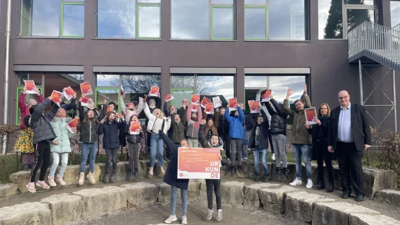Die Sch&uuml;ler der 5d freuen sich &uuml;ber die gelungene &Uuml;berraschung von Wettbewerbs-Leiter Hans-Georg Lambertz (rechts). Mit dabei sind auch Lehrerin Romy Br&uuml;ggemann und Lehrer Max Lendzian (weiter von rechts) sowie Schulleiter Markus Herrmuth (hinten, Mitte). - &copy; Lea Prawit