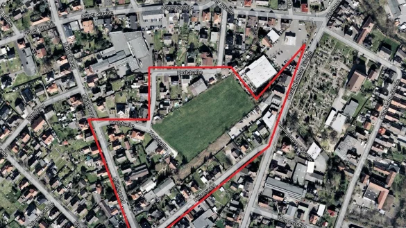 Das gro&szlig;e unbebaute Grundst&uuml;ck an der Karlstra&szlig;e liegt mitten in Sch&ouml;tmar. Im S&uuml;den befindet sich der Kiliansweg, im Westen der M&uuml;hlenweg, im Norden die Asper Stra&szlig;e und im Osten die Oerlinghauser Stra&szlig;e. Oberhalb grenzt die Wiese an den Raiffeisenmarkt auf dem alten &bdquo;Tivoli"-Gel&auml;nde. Das Gebiet des neu aufgestellten Bebauungsplans (rot umrandet) ist um einiges gr&ouml;&szlig;er. - &copy; Geobasis NRW