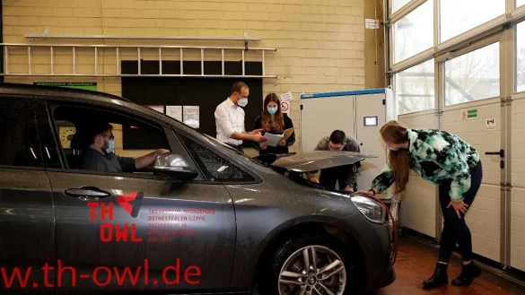 Studierende mit der Kraftstoffverbrauchsmessanlage (hinten rechts) bei der Vorbesprechung eines Laborversuchs am Rollenprüfstand. - © TH OWL