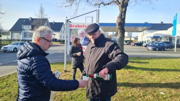 Ein Sektschl&uuml;ckchen zu Ehren des alten und neuen Bundespr&auml;sidenten: Dietmar K&ouml;ller schenkt Uwe von Glembotzki ein. Im Hintergrund Dr. Inga Kretschzmar vor dem Plakat, das die Dorfgemeinschaft gestern nach der Wahl aufgestellt hat: "Brakelsiek ist stolz auf Dich!" - &copy; Marianne Schwarzer(LZ)