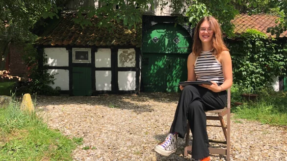 Lina Meier sitzt mit dem Tablet, den jedes Ratsmitglied von der Stadt bekommt, vor dem Kotten neben dem Wohnhaus, in dem sie lebt. Foto: Sven Kienscherf - &copy; Sven Kienscherf