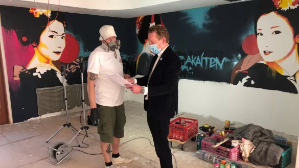 Knstler Elmar Lause und Christian Steffen vom Lippischen Hof besprechen das Wandmotiv.&nbsp; - &copy; Sven Kienscherf