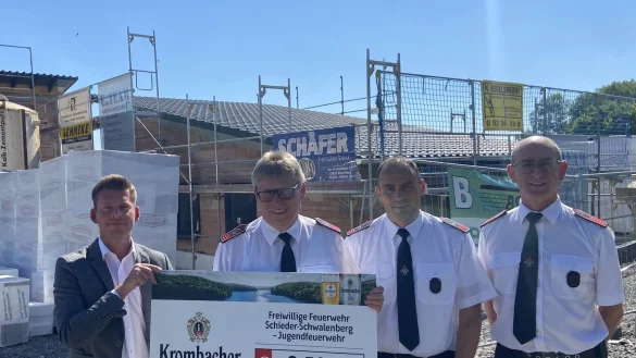 Beim der symbolischen Scheck&uuml;bergabe vor dem Bau des neuen Ger&auml;tehauses: (von links) Julian Kracht von der Krombacher Brauerei mit Thorsten M&uuml;hlenhof, Marco T&ouml;lle und R&uuml;diger Thalke von der Freiwilligen Feuerwehr Schieder-Schwalenberg. - &copy; Peter Lemm /Krombacher