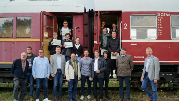 Gruppenfoto mit Projektteilnehmern, Kooperationspartnern und F&ouml;rderern vor dem Speisewagen der der LEL: (oben von links) Nick Lehn, Niklas Strate, Daniel Vogel, Lara Pleus, Moritz Kr&uuml;ger, Jonas Graap, Jonas Heinrichsmeyer und Maurice Block sowie (vorn von links) Industriemeister Werner Gerke, Mario Rehmsmeier (VBE), Thomas Mahlmann (zdi-Zentrum Lippe.MINT), Jochen Brunsiek (LEL), Sven Oehlmann (VBE), Bastian Ruhe (Sekundarschule Nordlippe), Christian Keller (Volksbank Bad Salzuflen), Leon M&ouml;nch, der stellvertretende Landrat Stephan Grigat und B&uuml;rgermeister Frank Meier. - &copy; Horst Kurzawski