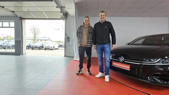 Teamleiter Sebastian Milde und Gesch&auml;ftsf&uuml;hrer Christoph Stricker stehen neben dem Drehteller der neuen Fahrzeugaufbereitung, mit dem die Gebrauchtwagen f&uuml;rs Internet automatisiert fotografiert werden k&ouml;nnen. - &copy; Jost Wolf