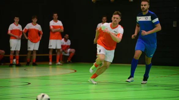 In Orange spielen die Mitarbeiter der Firma Weidm&uuml;ller, die am Ende den dritten Platz beim Turnier belegen, gegen das Team der Firma Bollhoff in blauen Trikots. - &copy; Nicole Ellerbrake