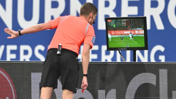 Schiedsrichter Florian Exner schaut sich am TV-Monitor den Zweikampf zwischen Marcel Hoffmeier und Joseph Hungbo an, der zum Foulelfmeter f&uuml;r N&uuml;rnberg f&uuml;hrt. - &copy; Imago Images/Sportfoto Zink