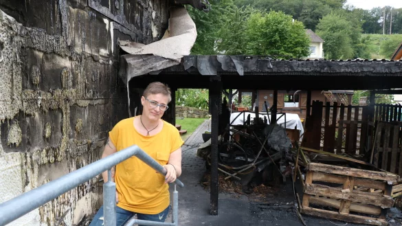 Miriam Kixm&ouml;ller-Mense steht vor dem abgebrannten Carport. Auch die Hausfassade muss komplett erneuert werden. - &copy; Alexandra Schaller