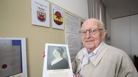 Helmuth Welsch zeigt ein Bild von F&uuml;rstin Pauline. Im Hintergrund ist das Alverdisser Wappen zu sehen. - &copy; Jens Rademacher