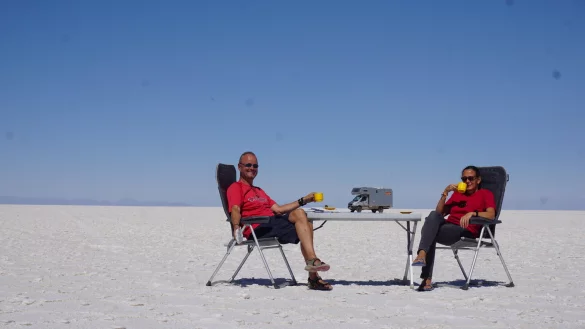Christin Behle und Thomas Hentzschel 2017 in der Salar de Uyuni in den Anden Boliviens. Die Salar gilt als "gr&ouml;&szlig;te Salzpfanne der Erde". Wie eine Fata Morgana scheint ihr Reisemobil auf dem Tisch zu stehen. - &copy; Hentzschel
