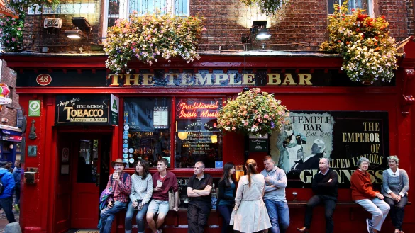 Die "Temple Bar" in Dublin mit einigen Gästen, die vor der Bar etwas trinken und zusammensitzen. - © Roland Marske