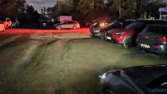 Eigentlich ist es hier stockduster. Bei der durch Autoscheinwerfer beleuchteten Szenerie hat die Kamera ein wahres Wunder bei der Bildaufhellung vollbracht. Hinter dem silbernen Kombi ist der geschotterte Bereich zu sehen, auf dem Baumaterialien gelagert werden. - &copy; Jost Wolf