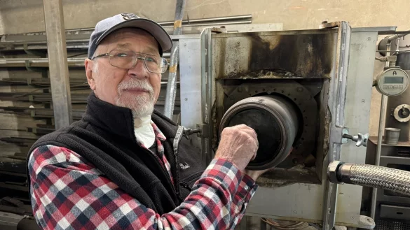 Hilmar Hubbes zeigt, wie die runde Retorte in den M&uuml;llvermeidungs-Ofen geschoben wird. - &copy; Sandra Castrup