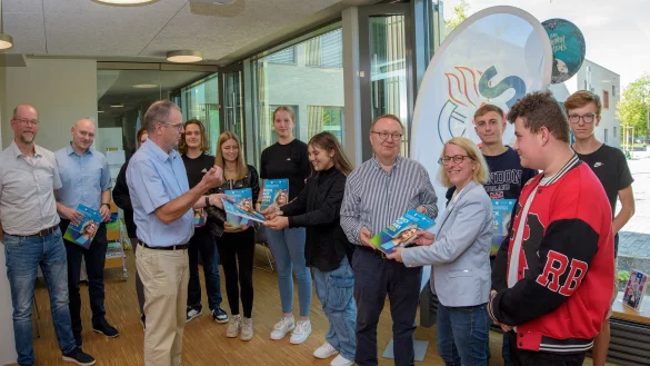 Seit Jahren ein unverzichtbares Medium f&uuml;r die Berufsorientierung: IHK-Vizepr&auml;sident Alfred W. Westermann (F&uuml;nfter von rechts) &uuml;berreicht das erste Exemplar an Schulleiterin Brigitta Wulf. Mit im Bild: Tobias Haak (Zweiter von links) und IHK-Bildungsgesch&auml;ftsf&uuml;hrer Michael Wennemann (Vierter von links). - &copy; YT