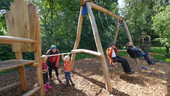Runa steht mit Kita-Leiterin Lara Trojak und Ilvi an der neuen Reckstange, die den Riesen-Stuhl mit den Schaukeln verbindet. Auf denen sitzen Tischerler Claus Amarell und der Vorsitzende des Tr&auml;gervereins Philipp Kaiser mit Martha (von links). - &copy; Jost Wolf