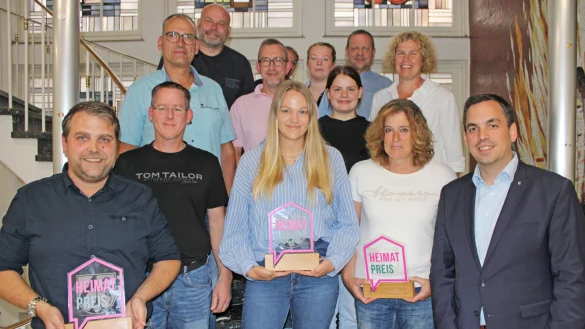 B&uuml;rgermeister Torben Blome (rechts) und die weiteren Jury-Mitglieder &uuml;berreichen die Troph&auml;en f&uuml;r den Heimatpreis. Ronny Engel mit Thomas Hagedorn (vorne von links, SV Niese), Gillian K&ouml;nig (IQ L&uuml;gde &ndash; SOS Kinderdorf) und Susanne M&uuml;ller (Dorfgemeinschaft Rischenau) nehmen sie stellvertretend entgegen. - &copy; Nico D&uuml;llmann