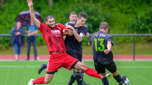 Alarm im Strafraum: Der Extertaler Kevin Elsner (rot) sorgt im Gästestrafraum für Gefahr. Fynn Amrhein (3, Kapitän) und Luca Simon Wolf (13) können mit vereinten Kräften den Ball aus der Gefahrenzone befördern. - © EGON PENNER