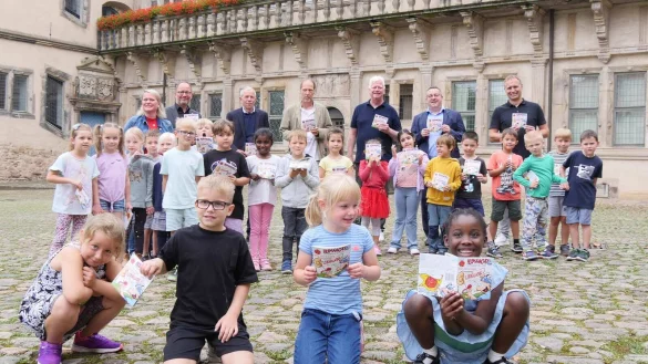 Freuen sich zusammen mit der 1a der Grundschule am Schloss: J&ouml;rg Franks, Schulleiter der Grundschule am Schloss, Landrat Dr. Axel Lehmann, Manfred H&uuml;tte, Verlagsleiter vom Kurier Verlag, Herm&auml;nnchen-Zeichner Mark Sch&auml;ferjohann, Dr. Albert H&uuml;ser, Vorsitzender vom Lippischen Heimatbund, J&ouml;rg D&uuml;ning-Gast, Verbandsvorsitzender vom Landesverband Lippe und Klassenlehrerin Alexandra Kehl (von rechts). - &copy; Kreis Lippe