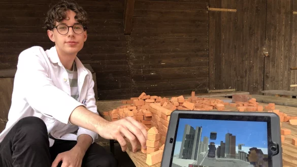 Bennet Grass zeigt im Ziegeleimuseum auf dem Tablet ein Bild von Minecraft. Dabei handelt es sich um eine Arbeit, die im Zuge des Minecraft-Projekts am Architekturmuseum Frankfurt entstanden ist. - &copy; Sven Kienscherf