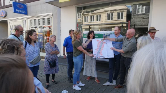 Projektleiter Christian Ahlers (Stadt Detmold) erl&auml;utert mit Laura Sch&auml;fer (DSK Stadtentwicklung) die Pl&auml;ne f&uuml;r den ersten Bauabschnitt der Langen Stra&szlig;e. Im Hintergrund stehen Henrik Hagemeister (Bauleitung Stadt Detmold) und Nadine Vormweg (Freiraumplanung Stadt Detmold), wie etwas verdeckt Peer Reese (Team Ordnung Stadt Detmold). - &copy; Jost Wolf