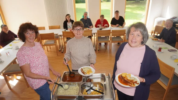 Susanne Koch (von links), Karola Durgeloh und Claudia richten das Essen auf den Tellern an. Manuela Todt-Reker (hinten, 2. von links) und Gudrun Tauer (rechts daneben) haben sich beim Mittagstisch kennengelernt. Zwischen ihnen ist eine Freundschaft entstanden. - &copy; Michaela Wei&szlig;e
