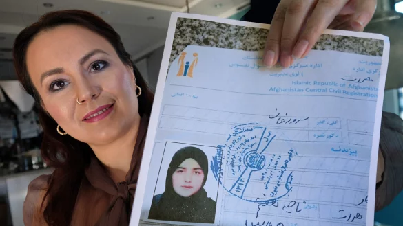 Lächeln nur für das Foto: Hale Harir hält ein Dokument, das ihre Großcousine Sadaaf zeigt. Täglich sorgt sie sich um das zwangsverheiratete Mädchen. - © Andreas Frücht