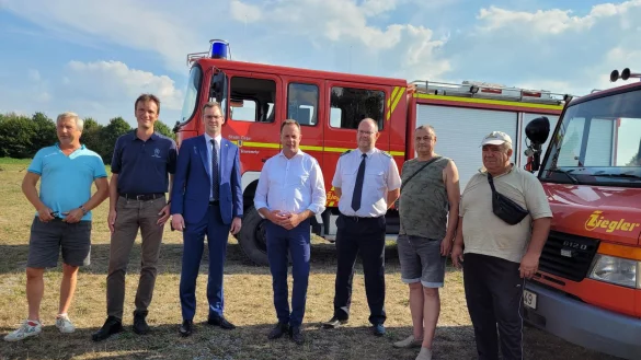 Uwe Kunk (von links) und Maximilian Braune haben die &Uuml;berf&uuml;hrung organisiert. B&uuml;rgermeister Matthias Kalkreuter, Ausschussvorsitzender Klaus Hansen und Feuerwehrchef Benjamin Brinkmeyer &uuml;bergeben die Feuerwehrfahrzeuge an Alexander Krimchak und Anatoli Monasrski. - &copy; Astrid Sewing