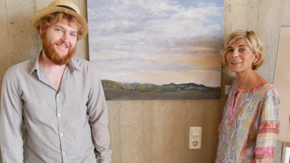 Der K&uuml;nstler Philipp Hiller und Kunsthistorikerin Vera Scheef stehen vorm Landschaftsbild "Unterwegs mit Lastenrad in Lippe" von Hiller, das zum Verkauf angeboten wird. - &copy; Thomas Kr&uuml;gler