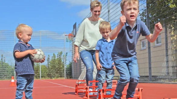 Fr&uuml;h &uuml;bt sich: Zuschauer Liam (v.l.), Mama Nicole mit Luca (3) und Levi (5) h&uuml;pfen im Schlusssprung &uuml;ber kleine H&uuml;rden - eine &Uuml;bung aus dem Anf&auml;ngertraining der Handballer, die man auf dem Sportfest ausprobieren konnte. - &copy; Sibylle Kemna