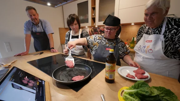 Anne Jost, Irene Regier und Liese Kempen (von links) machen heute Burger in der Eben-Ezer-Wohnanlage in der L&uuml;tzowstra&szlig;e. Dabei hilft ihnen als Pilotprojekt ein digitaler Kochassistent der Firma Miele. Projektmanager Matthias Stahl (Advanced Design bei Miele, ganz links) freut sich, dass es so gut klappt. - &copy; Jost Wolf