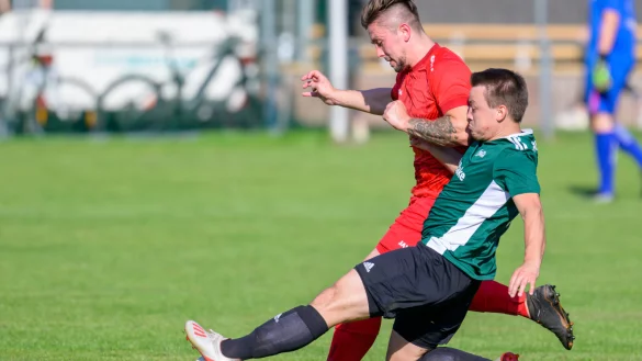 Der Oesterholzer Dominik L&uuml;ning (gr&uuml;n, vorne) kann in dieser Szene seinem Detmolder Gegenspieler Janick Bahms (rot) den Ball soeben noch wegspitzeln. - &copy; Egon Penner