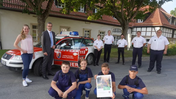 Westenergie-Kommunalmanagerin Maria Kemker (von links) und B&uuml;rgermeister J&ouml;rg Bierwirth zeichnen die Jugendfeuerwehrgruppe aus W&ouml;bbel mit dem Klimaschutzpreis aus. Diesen nehmen Fynn (vorne von links), Gina, Nik und Marvin entgegen. Mit ihnen freuen sich Mike Mundhenke (hinten von rechts), Leiter der Freiwilligen Feuerwehr, sowie Laurenz Meier, Till Wascher, Lukas Meier und Manuela Galsterer (alle L&ouml;scheinheit W&ouml;bbel). - &copy; Michaela Wei&szlig;e(LZ)
