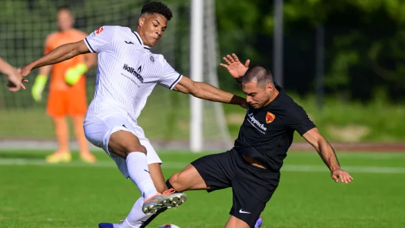 Kampfstark - Der Postler Konstantinos Triantafillidis (schwarz, rechts) geht mit vollem Risiko gegen den Delbr&uuml;cker Patrice Yoann Heisinger in den Ball. - &copy; Egon Penner