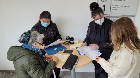 Ebru Birincioglu (Zweite von rechts) und ihre Kollegin Cigdem &Ouml;nen haben zwei Schecks vorbereitet, die sie an ukrainische Fl&uuml;chtlinge &uuml;bergeben. Das Sozialamt Lage hatte schon kurz nach der Ankunft der ersten Fl&uuml;chtlinge eine einfache Geldausgabe mit der Sparkasse am Markt organisiert. Es ist eine Aufgabe von vielen, die zus&auml;tzlich bew&auml;ltigt werden m&uuml;ssen. - &copy; Astrid Sewing