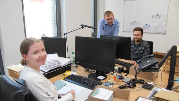 Naomi Slotta packt die Briefwahlunterlagen in die Umschl&auml;ge, w&auml;hrend Detlef Slotta Azubi Anastasios Katsaros &uuml;ber die Schulter schaut.&nbsp; - &copy; Nadine Uphoff