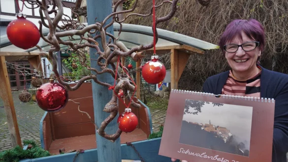 Regina Zelms, Vorsitzende des Kelter- und Kulturvereins, präsentiert den neuen Schwalenberg-Kalender. Insgesamt sind 750 Exemplare erhältlich. - © Michaela Weiße(LZ)