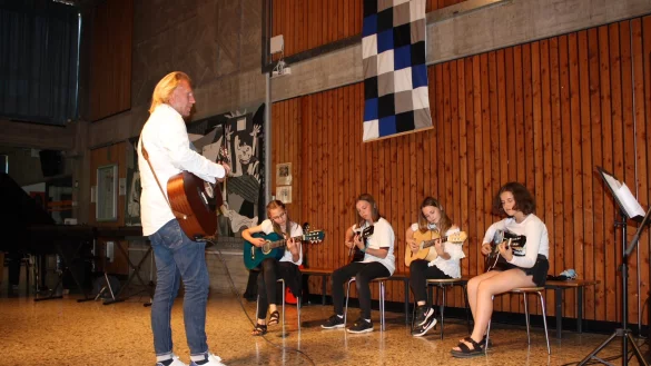 Musiklehrer Phillip Meyer und einige Sch&uuml;lerinnen an der Gitarre. - &copy; Realschule Lemgo