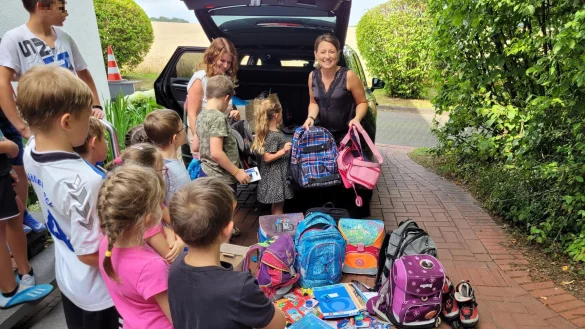 Kita-Leiterin Anna Schellenberg (links) und Lydia Epp packen den Kofferaum aus und verteilen das Schulmaterial an die Heimkinder. Diese freuen sich &uuml;ber die Ranzen und Rucks&auml;cke. - &copy; Astrid Sewing