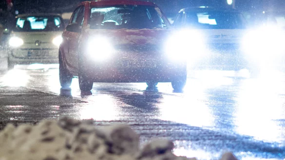 Autos fahren am frühen Wintermorgen eine Straße entlang. - © Moritz Frankenberg/dpa