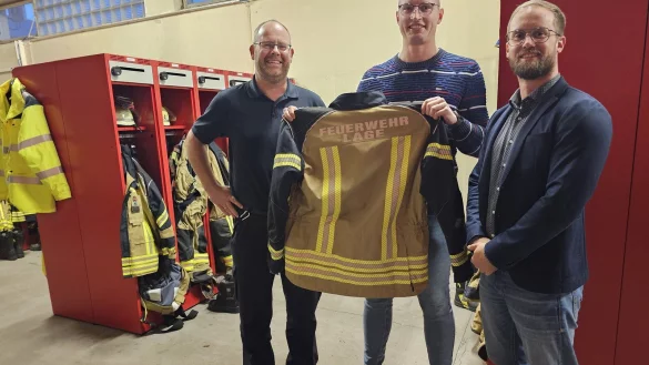 Wehrleiter Benjamin Brinkmeyer, Pressesprecher Carlos Hummerjohann und Fachgruppenleiter Malte Begemann zeigen eine Testjacke. Weil sie rundum mit Reflektorstreifen vershen ist, entf&auml;llt die Pflicht, Warnwesten zu tragen. - &copy; Astrid Sewing