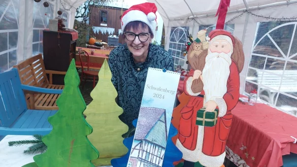 Regina Zelms, Vorsitzende des Kelter- und Kulturvereins, pr&auml;sentiert den neuen Schwalenberg-Kalender. - &copy; Michaela Wei&szlig;e
