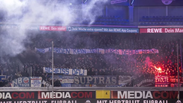Rostocker Fans protestieren mit Bannern und Pyrotechnik gegen die DFL und Investoren. - &copy; David Inderlied/dpa