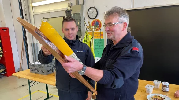 Der Leiter Atemschutz der Freiwilligen Feuerwehr Bad Salzuflen, Timo Wessel (links), &uuml;berreicht Willi Schmidtpott als Geschenk eine speziell pr&auml;parierte Atemluftflasche. - &copy; Daniel Hobein / Feuerwehr Bad Salzuflen