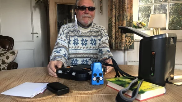 Vor Gerhard Steffen liegen verschiedenen technische Hilfsmittel, die ihm das Leben erleichtern. Ganz rechts ist das Vorlesegerät zu sehen, das Texte erkennt, die man unter die Kamera legt. - © Sven Kienscherf